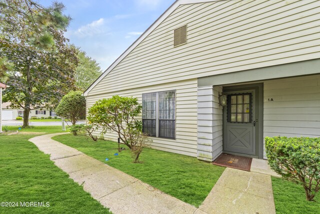 property entrance featuring a lawn