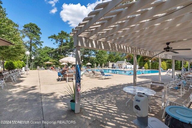 view of pool with ceiling fan, a pergola, and a patio