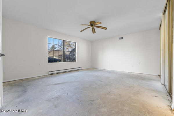 spare room with ceiling fan and baseboard heating