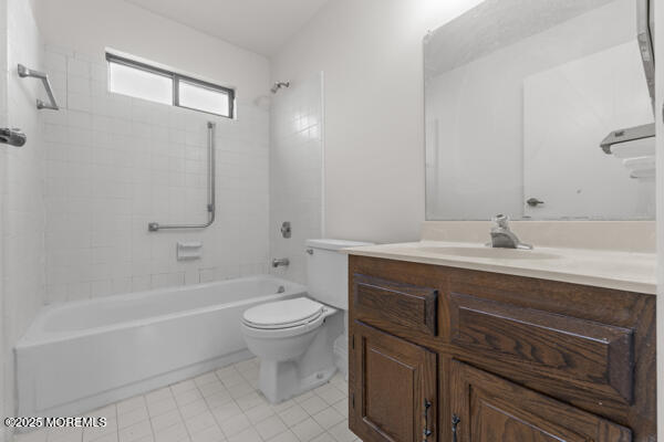 full bathroom featuring vanity, tile patterned flooring, tiled shower / bath combo, and toilet