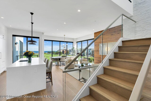 stairway featuring hardwood / wood-style flooring and a notable chandelier