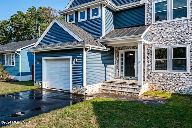 view of exterior entry with a yard and a garage