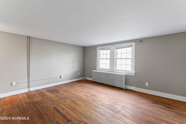 spare room with radiator and wood-type flooring