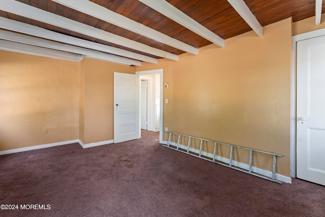 carpeted spare room with wood ceiling and beam ceiling