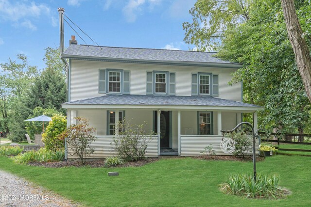 view of front of home with a porch and a front lawn