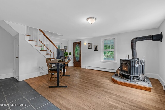 entryway with hardwood / wood-style flooring, baseboard heating, and a wood stove