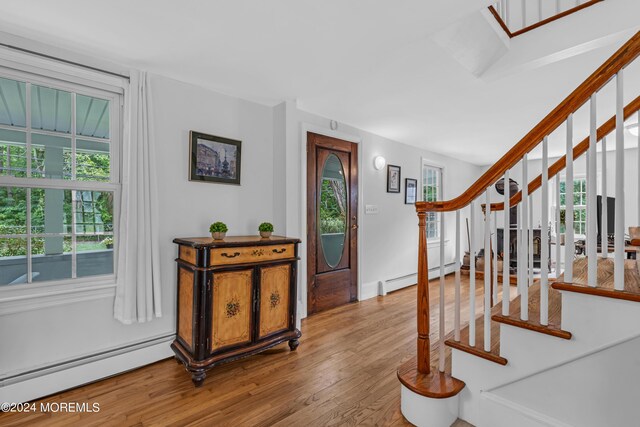 foyer entrance with a baseboard heating unit and hardwood / wood-style floors