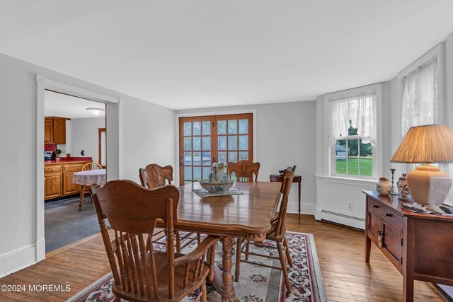 dining space with wood-type flooring and baseboard heating