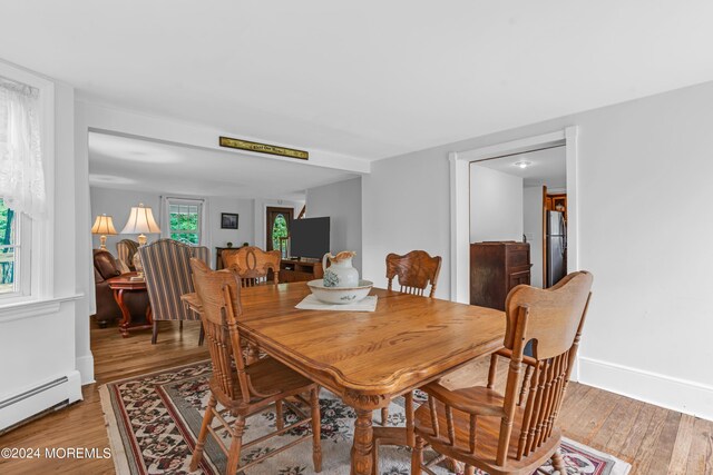 dining area with a baseboard radiator and hardwood / wood-style flooring