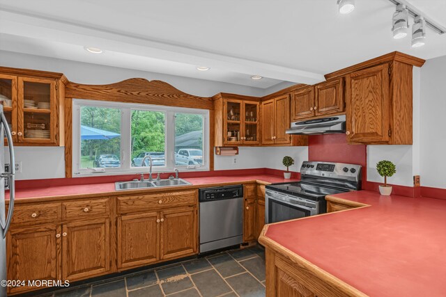 kitchen featuring sink, appliances with stainless steel finishes, and dark tile patterned flooring