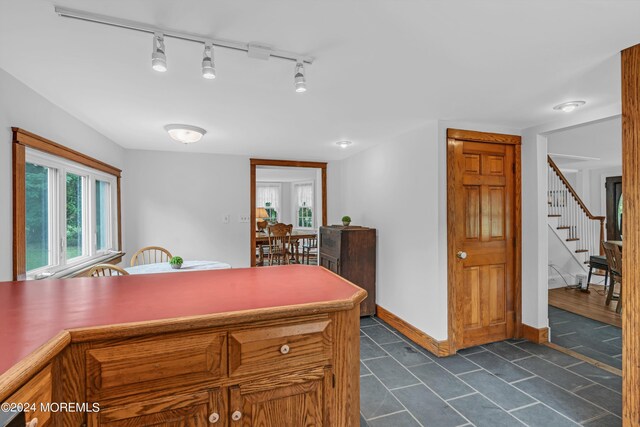 kitchen featuring rail lighting and dark tile patterned flooring