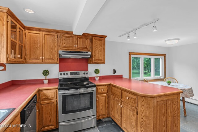 kitchen with appliances with stainless steel finishes, kitchen peninsula, and tile patterned flooring