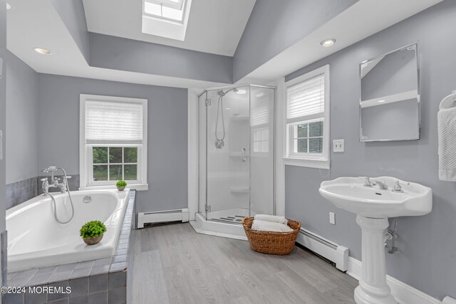 bathroom featuring a baseboard heating unit, hardwood / wood-style floors, and shower with separate bathtub