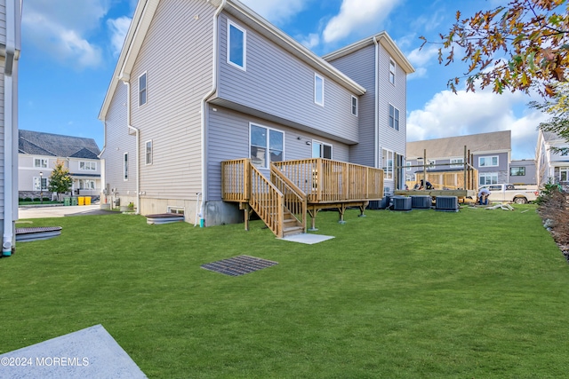 rear view of property with a yard, cooling unit, and a wooden deck