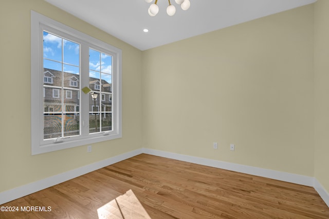 unfurnished room featuring light hardwood / wood-style flooring and a chandelier