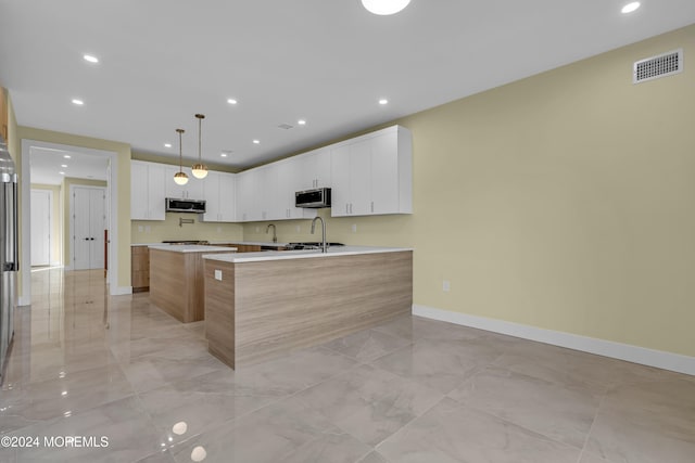 kitchen with white cabinetry, a kitchen island, and pendant lighting