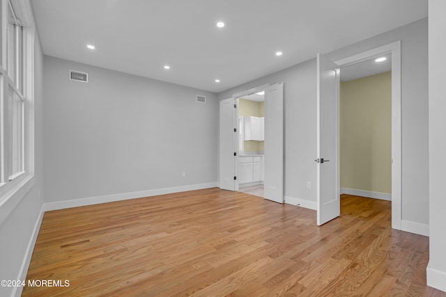 unfurnished bedroom with connected bathroom and light hardwood / wood-style floors