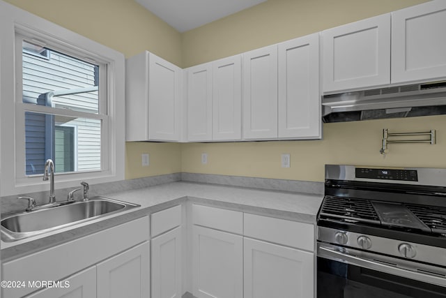 kitchen featuring white cabinetry, stainless steel range oven, and sink