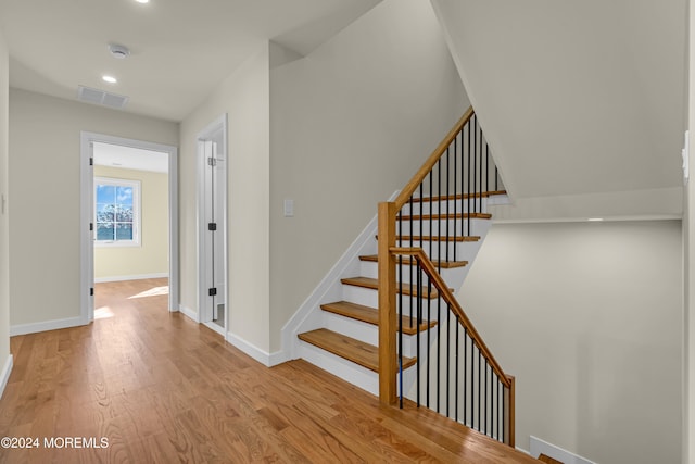 staircase with hardwood / wood-style flooring