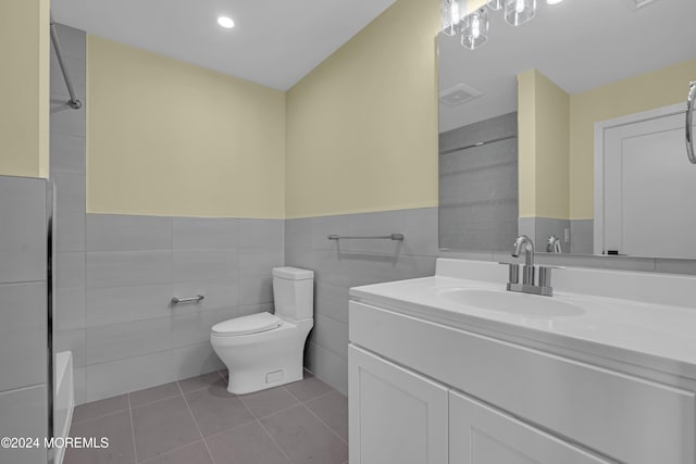 bathroom featuring vanity, tile walls, toilet, and tile patterned flooring