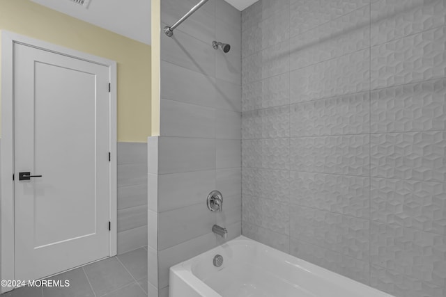 bathroom with tiled shower / bath and tile patterned flooring