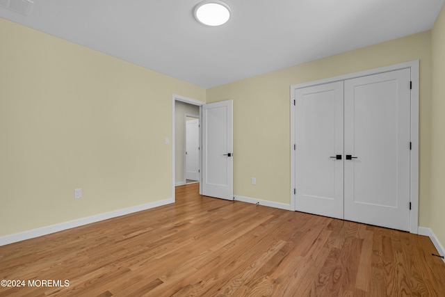 unfurnished bedroom with light hardwood / wood-style floors and a closet