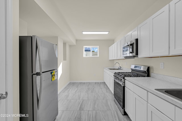 kitchen with sink, appliances with stainless steel finishes, and white cabinets