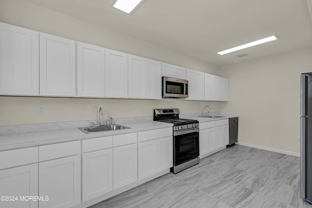 kitchen featuring sink, appliances with stainless steel finishes, and white cabinets