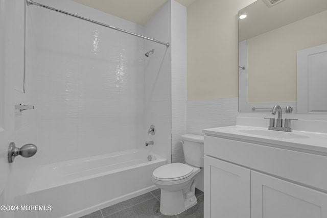 full bathroom with tile walls, toilet, shower / bathtub combination, vanity, and tile patterned flooring