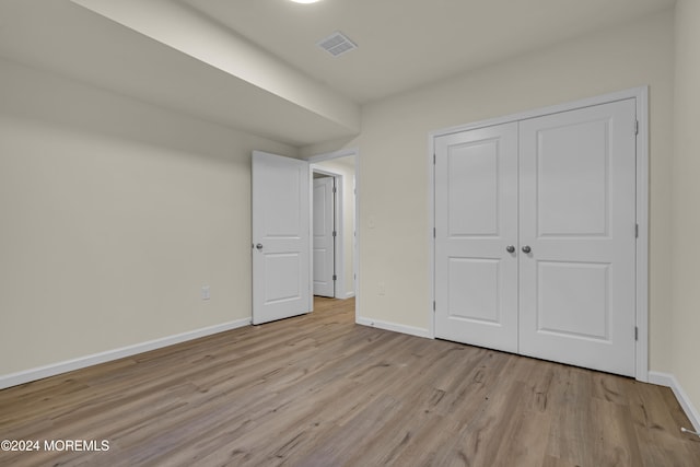 unfurnished bedroom with a closet and light wood-type flooring