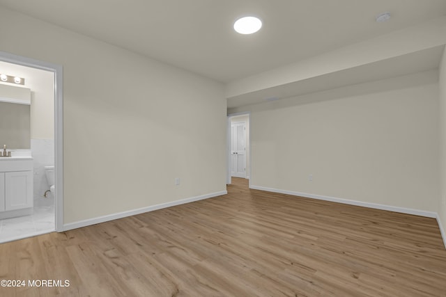 spare room with sink and light wood-type flooring