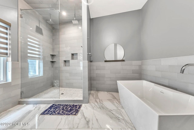 bathroom featuring tile walls, separate shower and tub, and vaulted ceiling