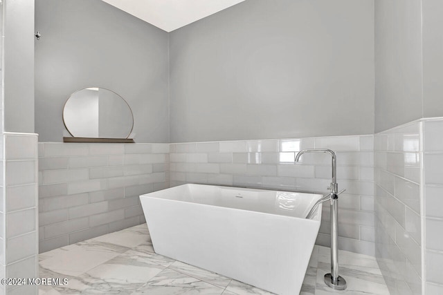 bathroom featuring a tub and tile walls