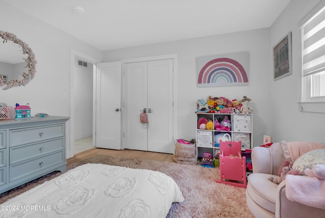 bedroom with light wood-type flooring and a closet