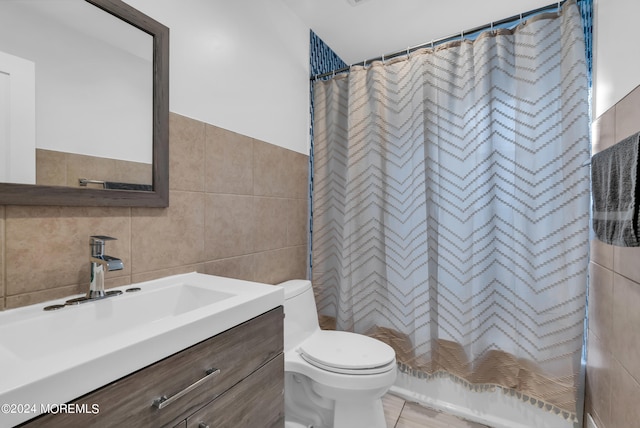 full bathroom with shower / bath combination with curtain, vanity, toilet, tile walls, and tile patterned flooring