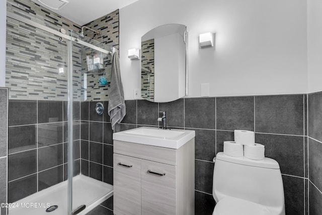 bathroom featuring vanity, tile walls, toilet, and an enclosed shower