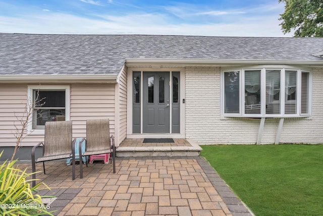 doorway to property featuring a yard and a patio