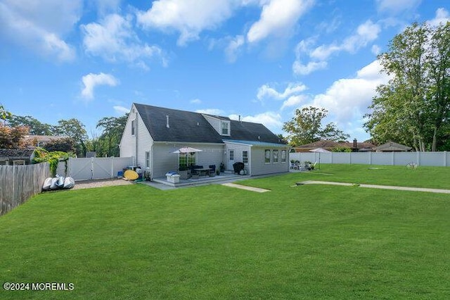 rear view of house featuring a patio area, a fenced backyard, and a lawn