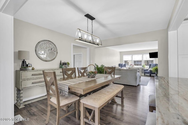 dining room with dark wood-style floors and a chandelier