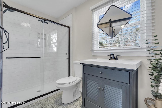 full bath featuring toilet, a stall shower, and vanity