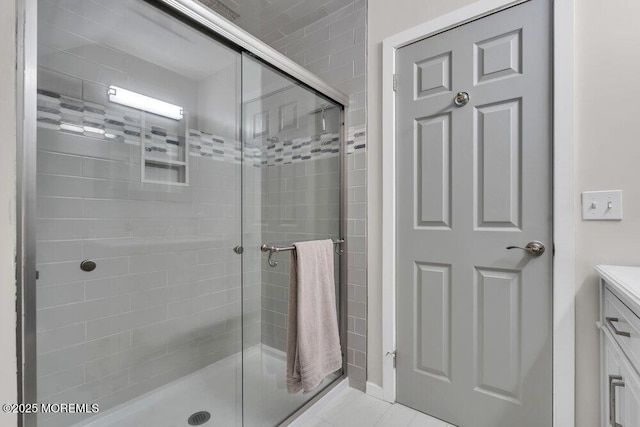 full bath featuring a shower stall, vanity, and tile patterned floors