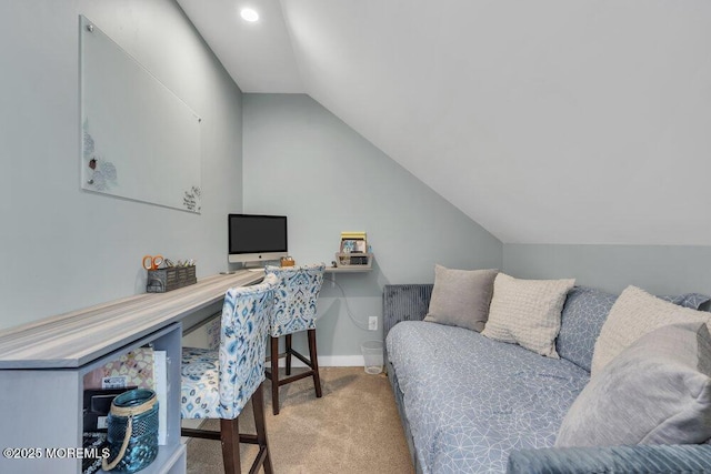 carpeted office with lofted ceiling and baseboards