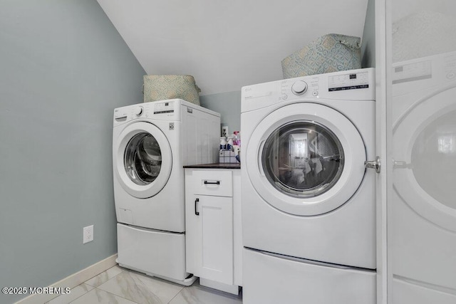 washroom featuring marble finish floor, baseboards, and washer and clothes dryer