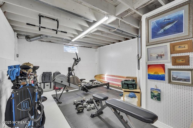 exercise room featuring concrete block wall