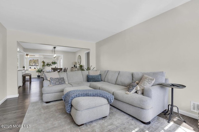 living area with baseboards and wood finished floors