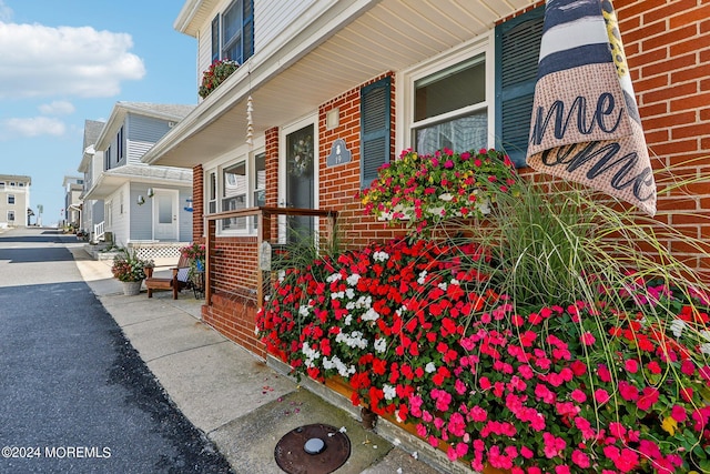 view of side of property with brick siding and a porch