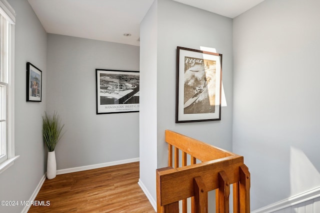 corridor with wood finished floors and baseboards