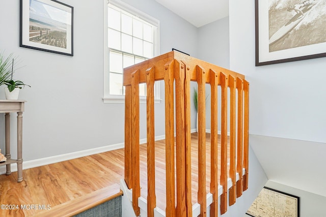 stairway with wood finished floors and baseboards