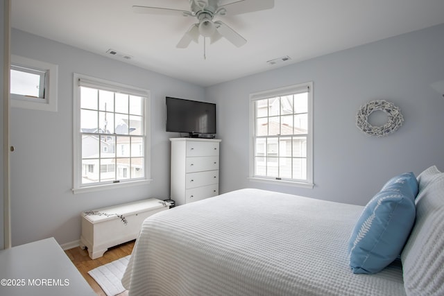 bedroom with light wood-type flooring, baseboards, and a ceiling fan