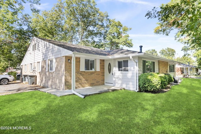 rear view of property featuring a lawn